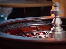 Live dealer at Ways of the Qilin table with card shoe and betting layout